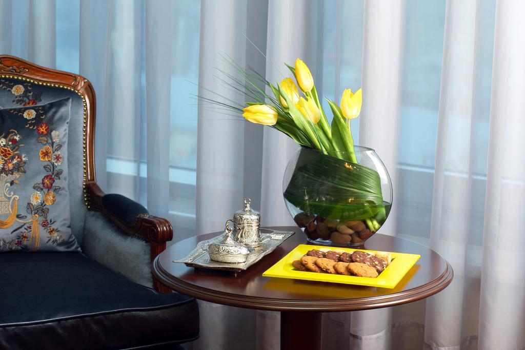 Orion Hotel Bishkek Exterior photo A table with a vase of flowers